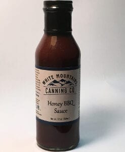 A bottle of honey bbq sauce on a white background.