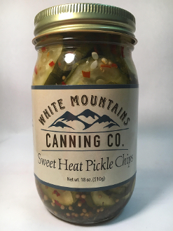 A jar of pickles with white mountains canning co. Label
