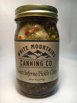 A jar of pickles with white mountains canning company label.