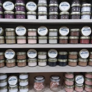 A shelf filled with jars of different colors and sizes.