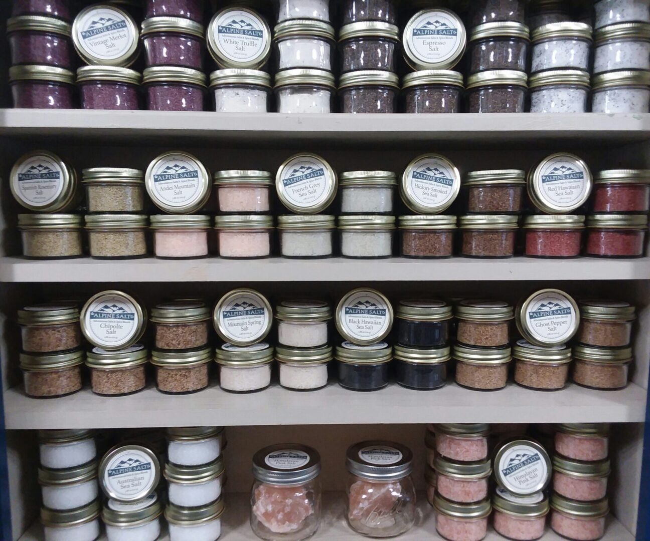 A shelf filled with jars of different colors and sizes.