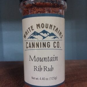 A jar of mountain rib rub on top of a table.