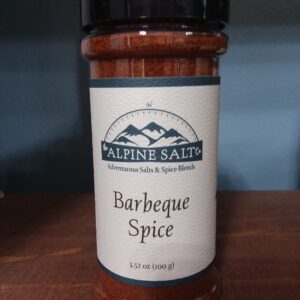 A jar of barbecue spice on top of a table.