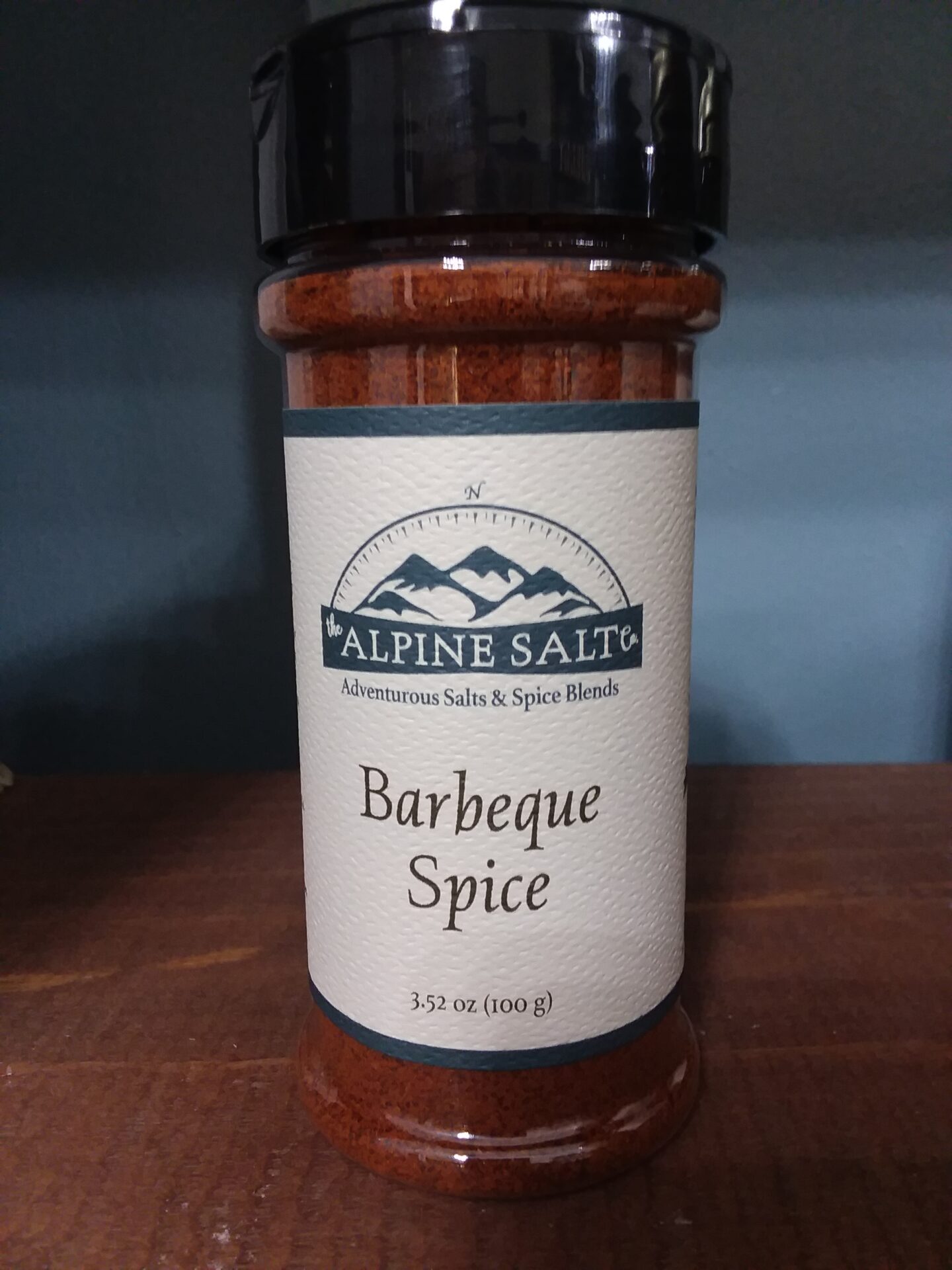 A jar of barbecue spice on top of a table.