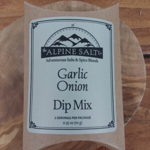 A bag of garlic onion dip mix on top of a wooden plate.