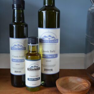 Three bottles of olive oil on a table.