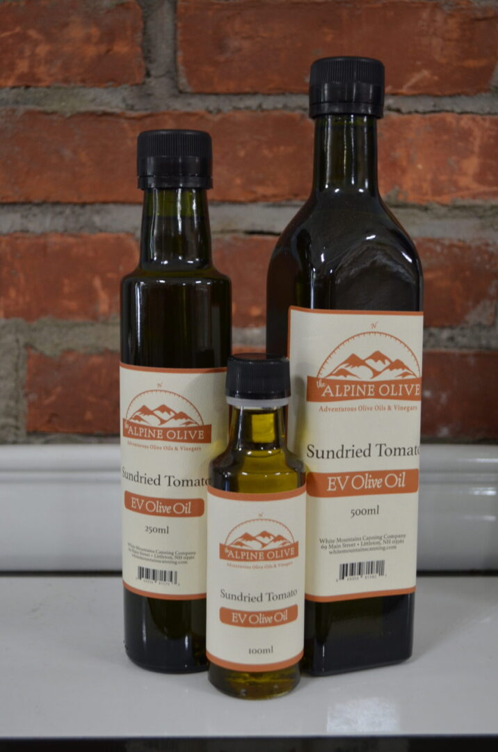 Three bottles of olive oil on a counter.