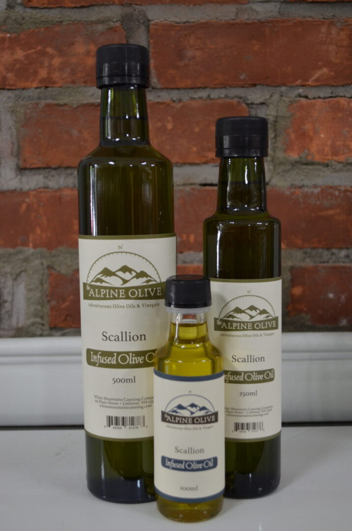 Three bottles of olive oil are shown with a small bottle.