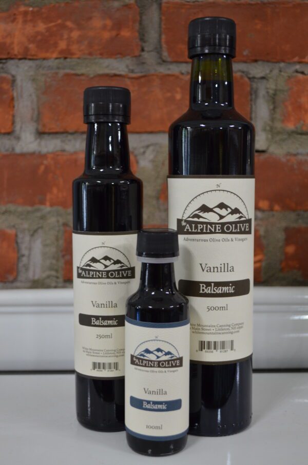 Three bottles of vanilla flavored oil on a counter.