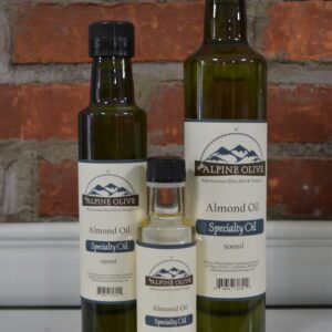 Three bottles of almond oil sitting on a counter.