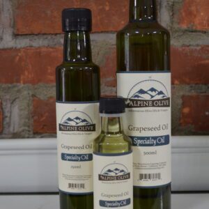 Three bottles of grapeseed oil on a counter.
