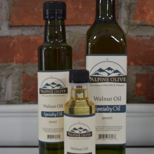Three bottles of walnut oil on a counter.