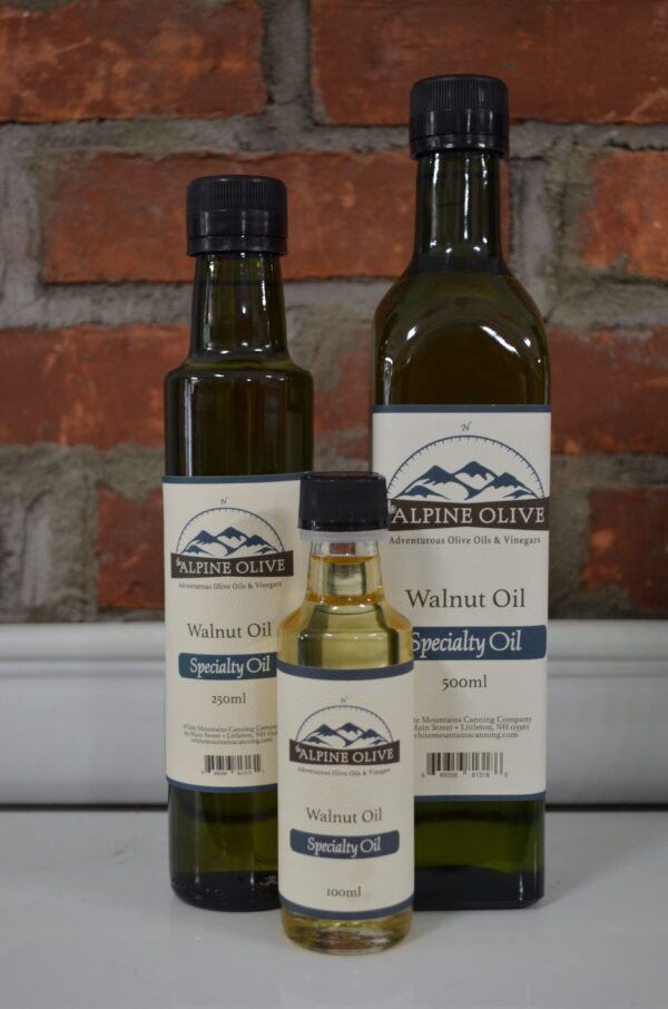 Three bottles of walnut oil on a counter.