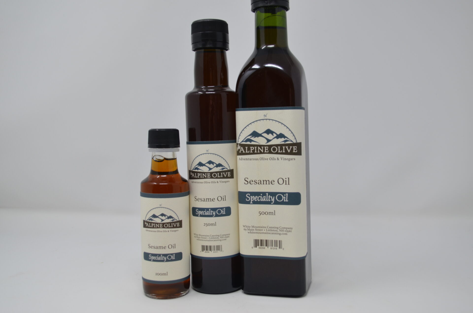Three bottles of oil are shown on a white background.
