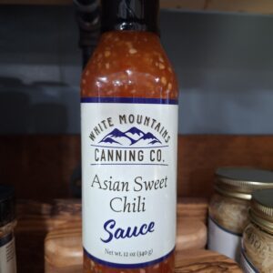Asian sweet chili sauce bottle on shelf.