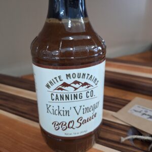 BBQ sauce bottle on wooden surface.